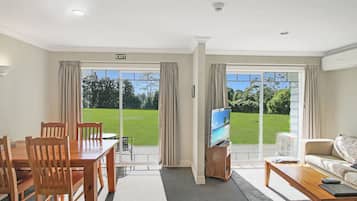 Premium suite, 1 slaapkamer, bubbelbad, uitzicht op tuin | Woonruimte | Een 40-inch televisie met kabelzenders