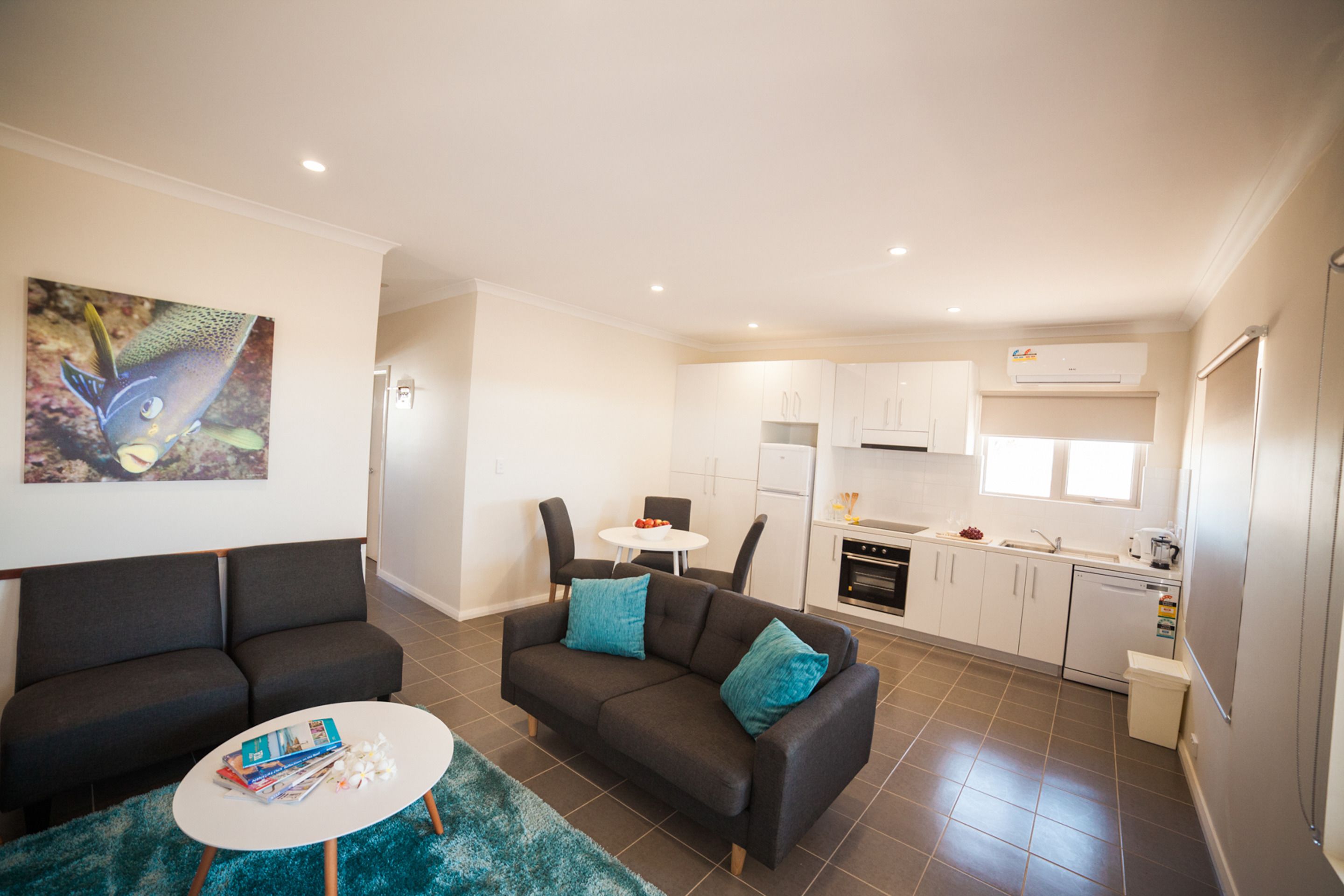 A modern apartment with a living area, kitchenette, and a dining table.