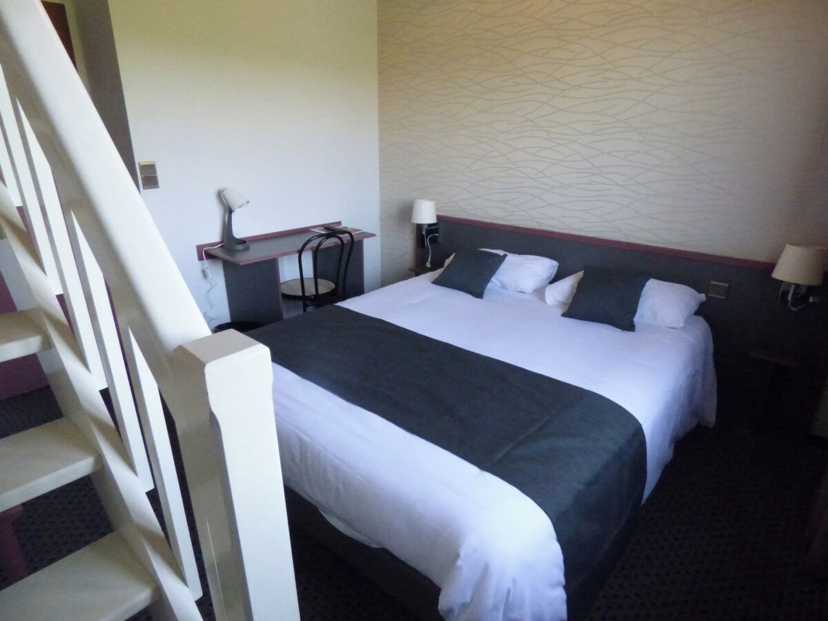 Een hotelkamer met twee bedden, een bureau en een stoel.
