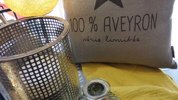 A decorative lamp, a glass vase, and a pillow with text on a table.