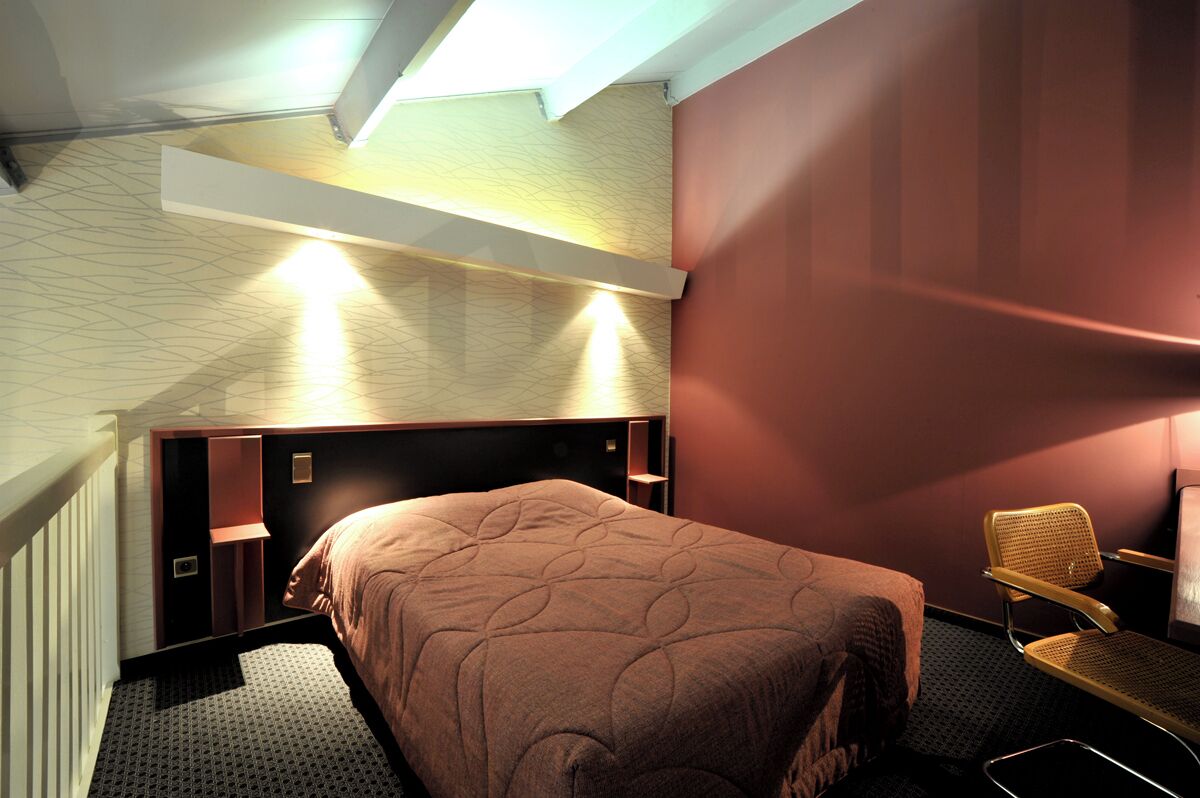 Una habitación de hotel moderna con una cama grande, un escritorio y una silla.