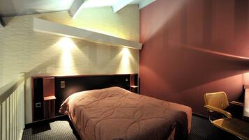Una habitación de hotel moderna con una cama grande, un escritorio y una silla.
