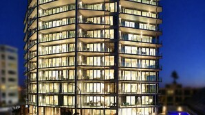 A multi-story hotel with a modern design, featuring balconies and a pool area. - The Pacific Apartments (Tauranga)