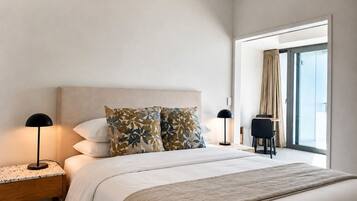 Un dormitorio moderno con una cama grande, dos mesitas de noche, una ventana con cortinas y vistas al exterior.