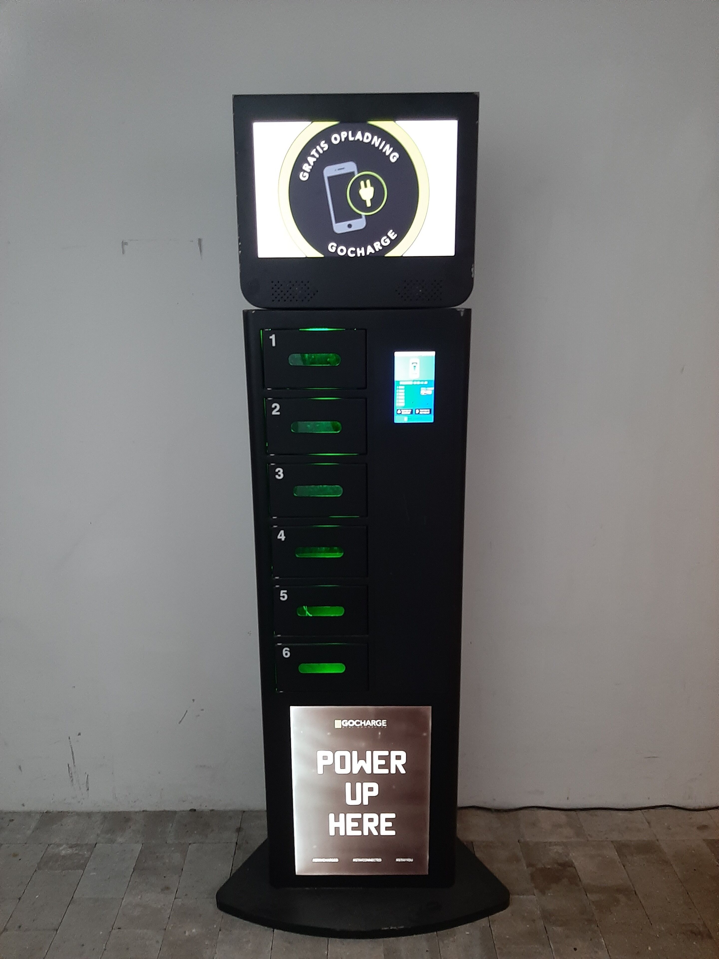 Una estación de carga negra con una pantalla que muestra los textos 