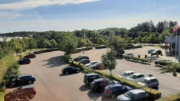 A parking lot with multiple cars, trees, and a building labeled 'Sydbank'.