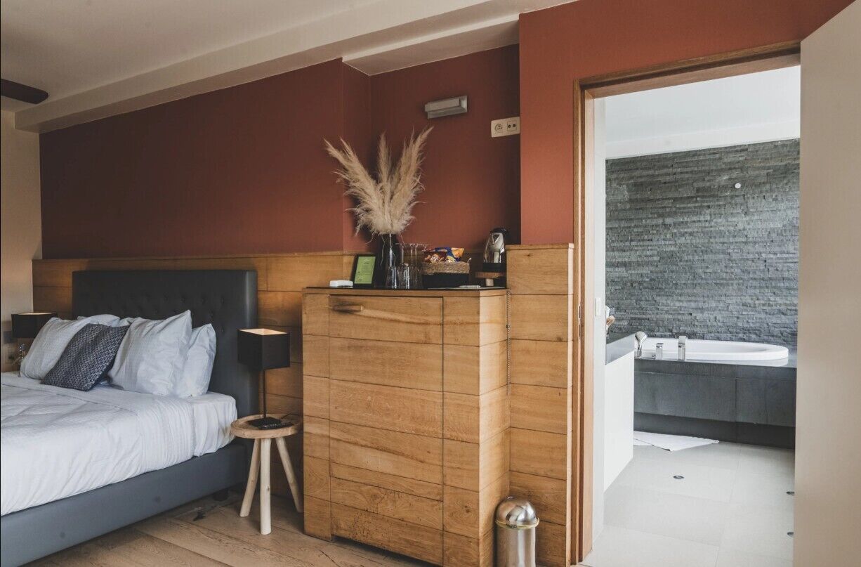 Un dormitorio con cama, mesita de noche y cómoda de madera.