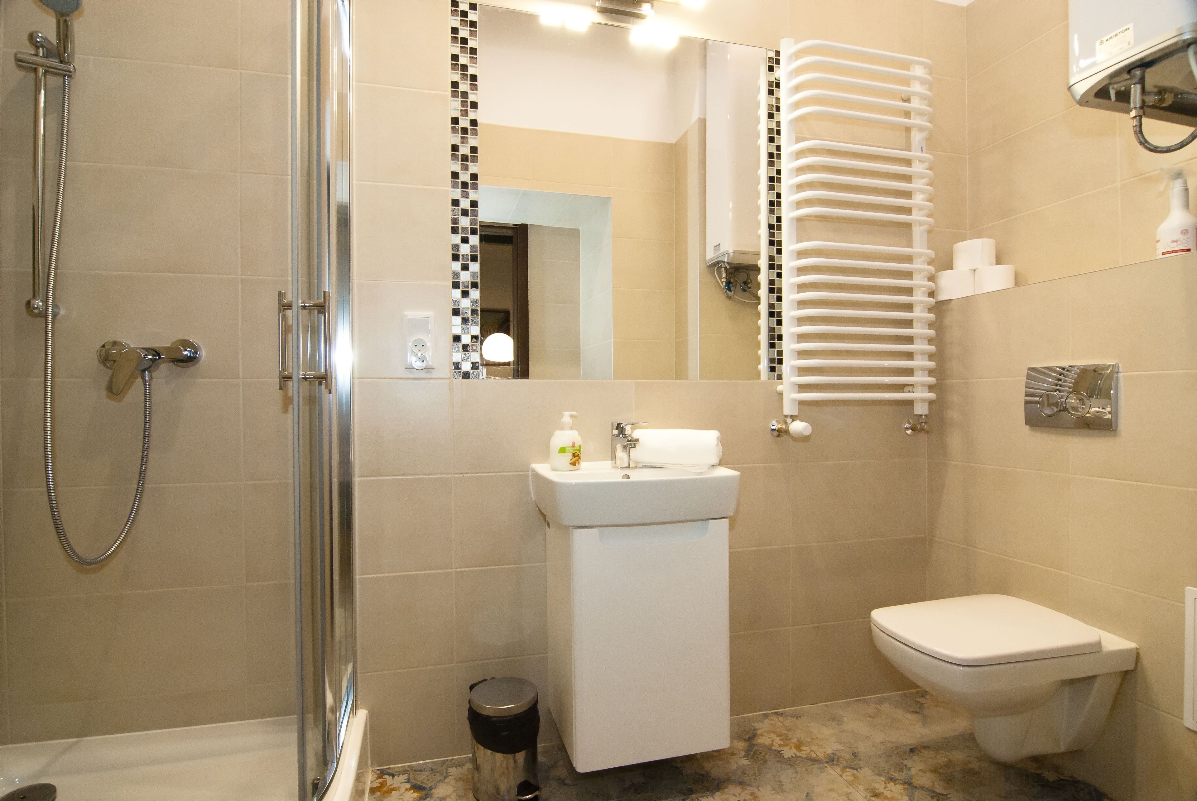 Ein Badezimmer mit Dusche, Waschbecken, Toilette und Handtuchhalter.