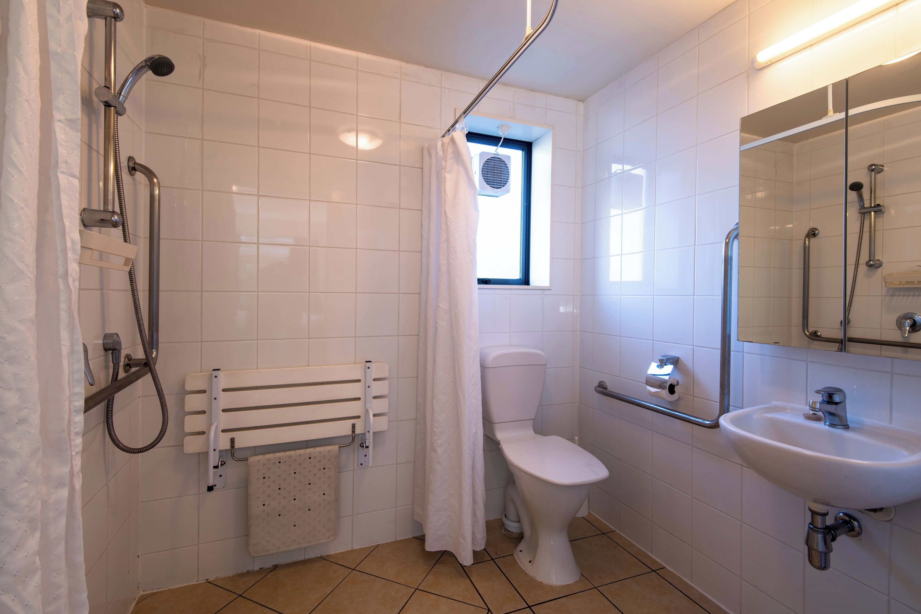 Ein Badezimmer mit Dusche, Toilette und Waschbecken.