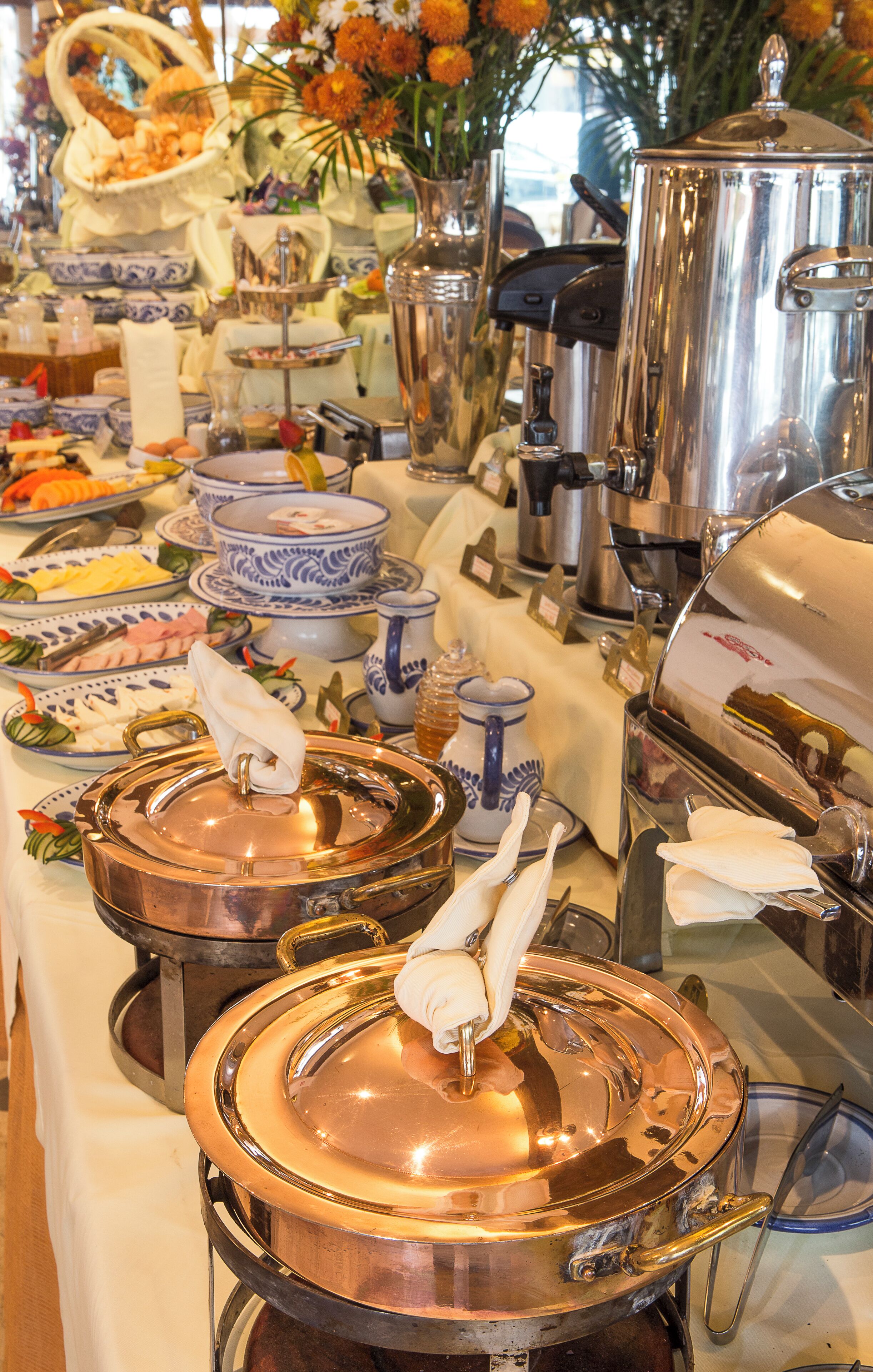 Un buffet proposant une variété de plats et d’ustensiles de service.