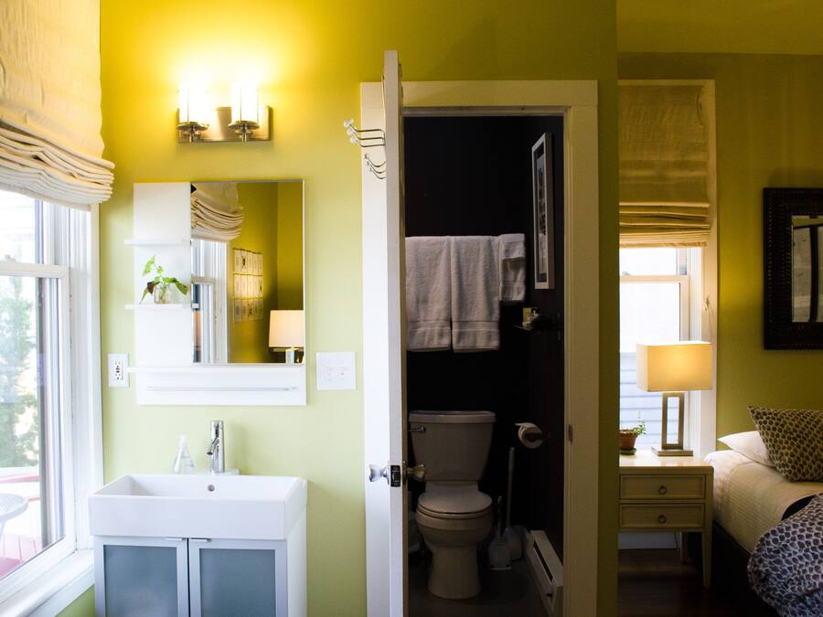 Un baño con lavamanos, inodoro y espejo.