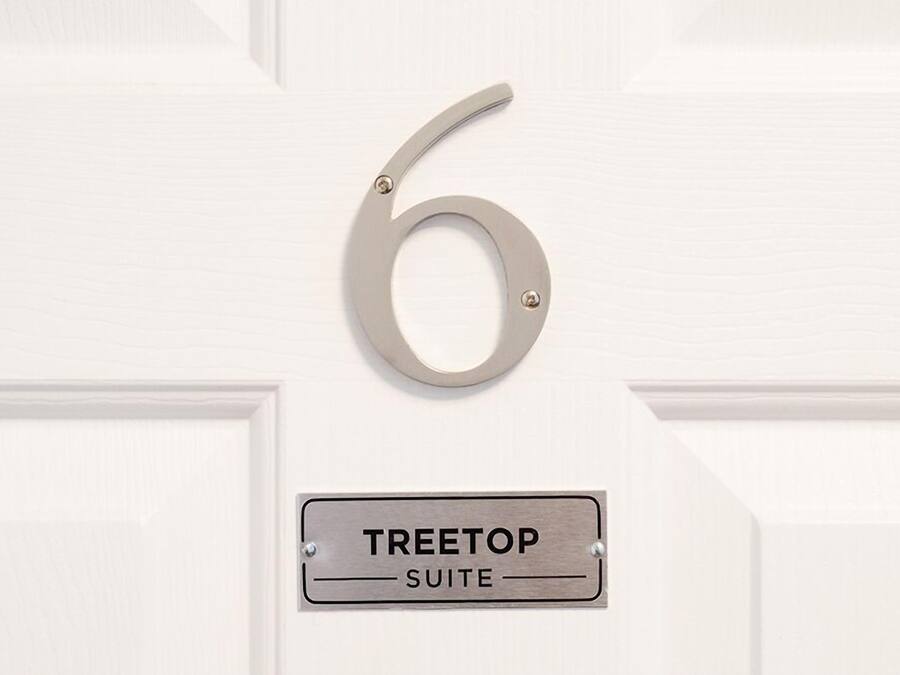 Eine Tür mit der Nummer 6 und einem Schild, das 'TREETOP SUITE' zeigt.