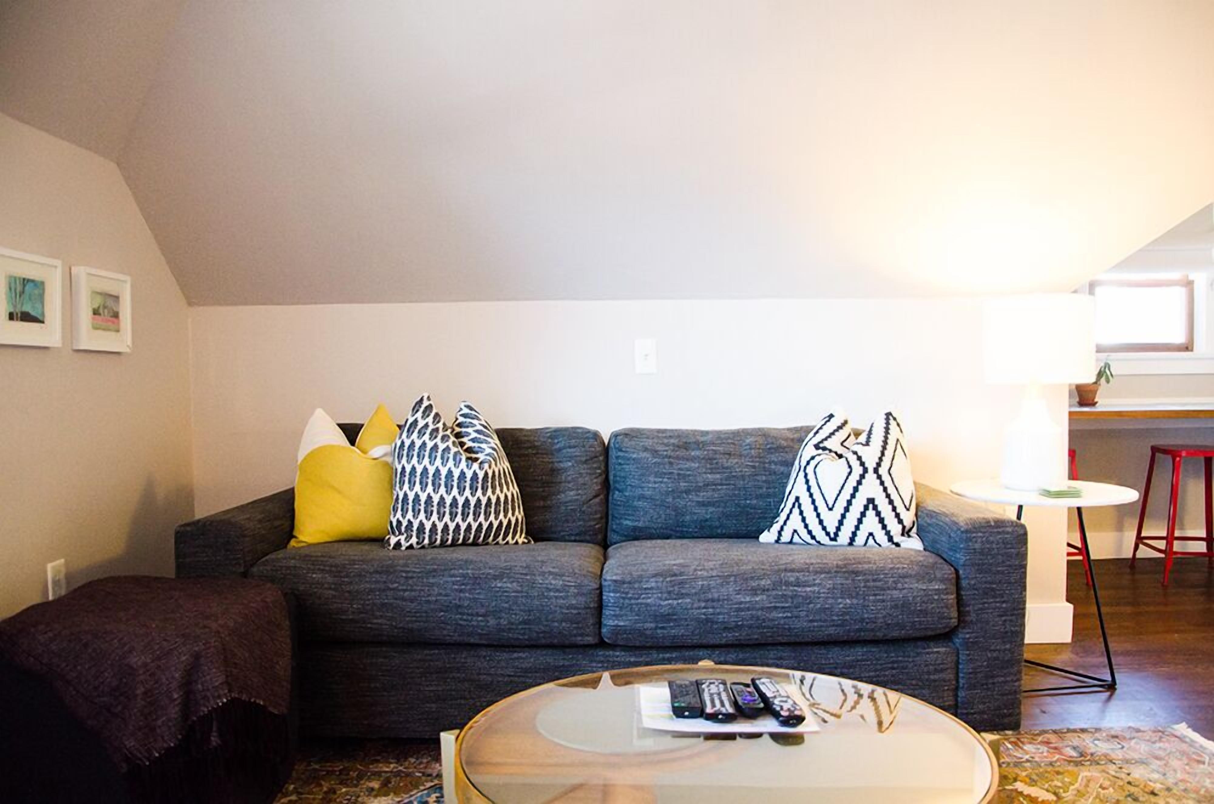 A living room with a grey sofa, a round coffee table, and a small side table with a lamp.
