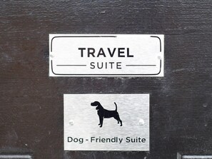 Señal que indica una 'Travel Suite' y una 'Suite para mascotas', con el silueta de un perro.