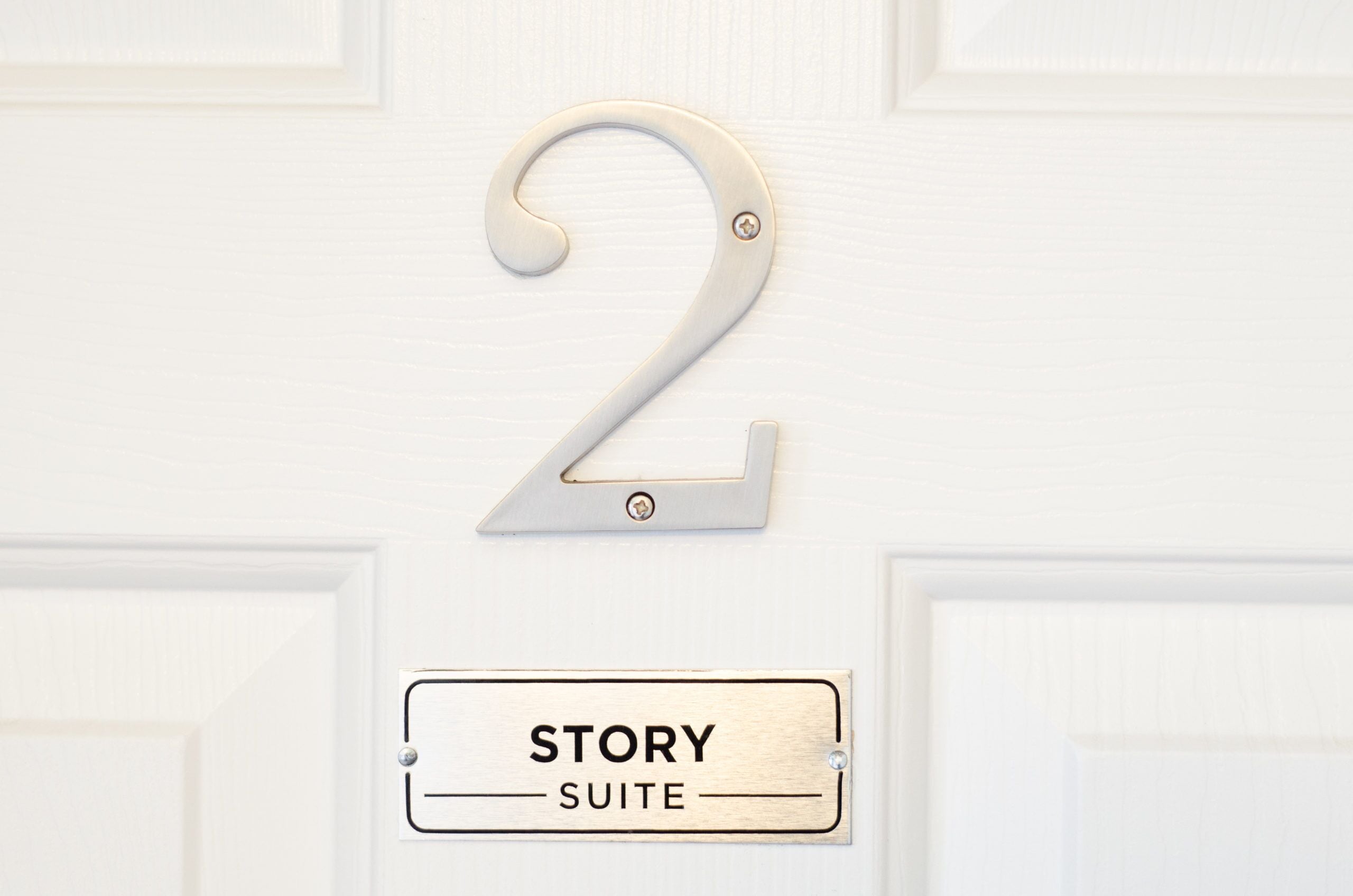 A door with a number 2 sign and a label reading "STORY SUITE".