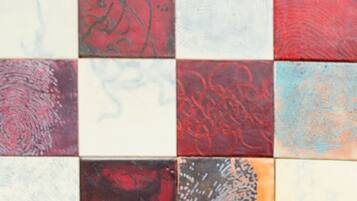 A tiled wall with various patterns and textures.