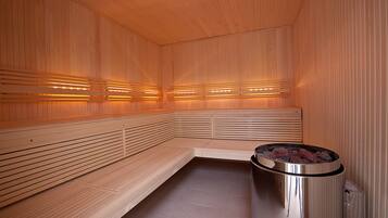 Een sauna met houten banken en een centrale verwarming.