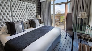Una habitación de hotel con una cama grande, una mesa de vidrio y vistas al exterior.
