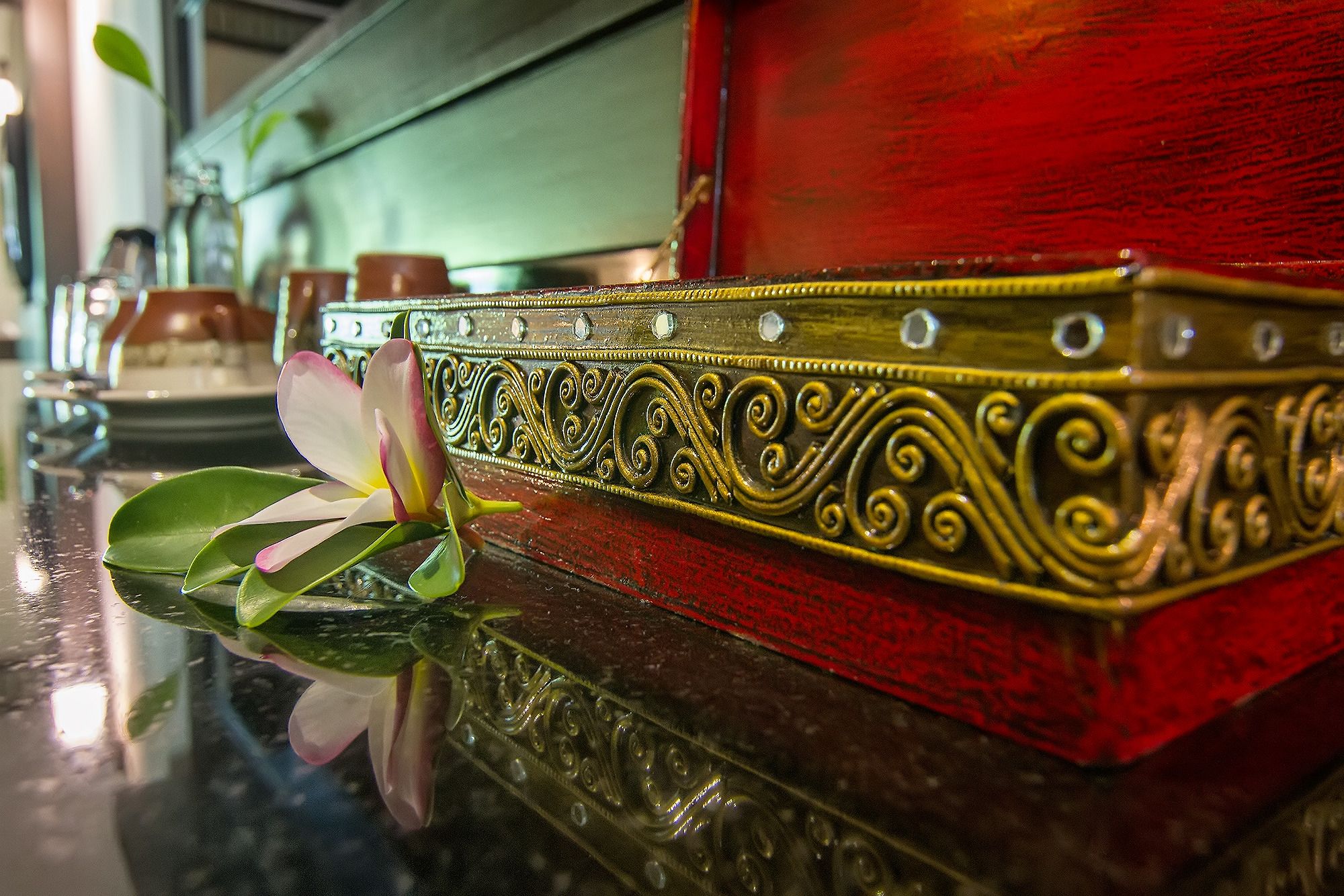 A close-up of a decorative, ornate box with intricate designs and a reflective surface.