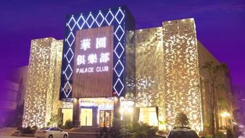 A building with a large illuminated sign reading 'PALACE CLUB' and a modern architectural design.