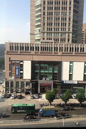 A multi-story building with a large entrance, several windows, and a visible signboard. - Century Palace Hotel (Huizhou)