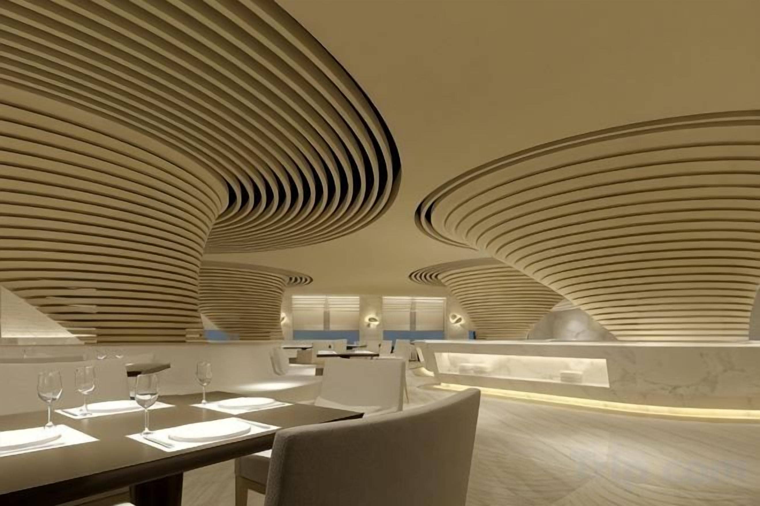 A modern interior with curved ceiling designs, a dining area with tables and chairs, and a bar area.