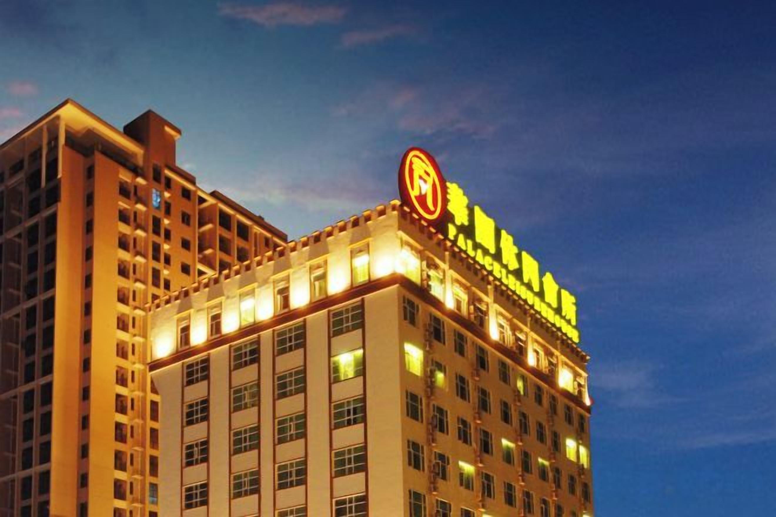 Un edificio de hotel de varios pisos con señalización iluminada y un logotipo circular destacado en la fachada.