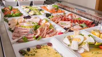 Un buffet proposant une variété de plats, notamment des viandes, des fromages et des salades.