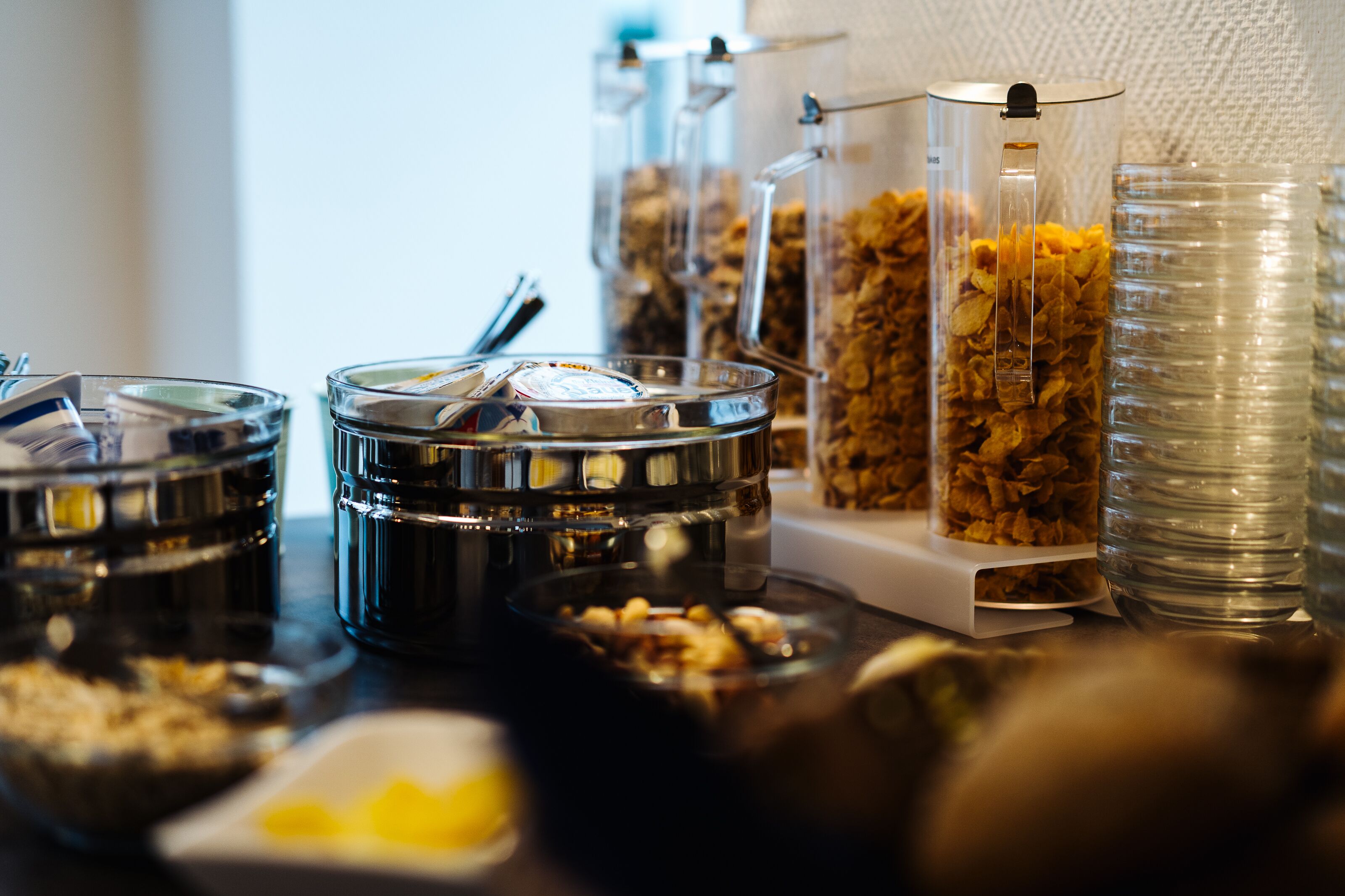 Un bufé de desayuno con varios recipientes y utensilios para la comida.