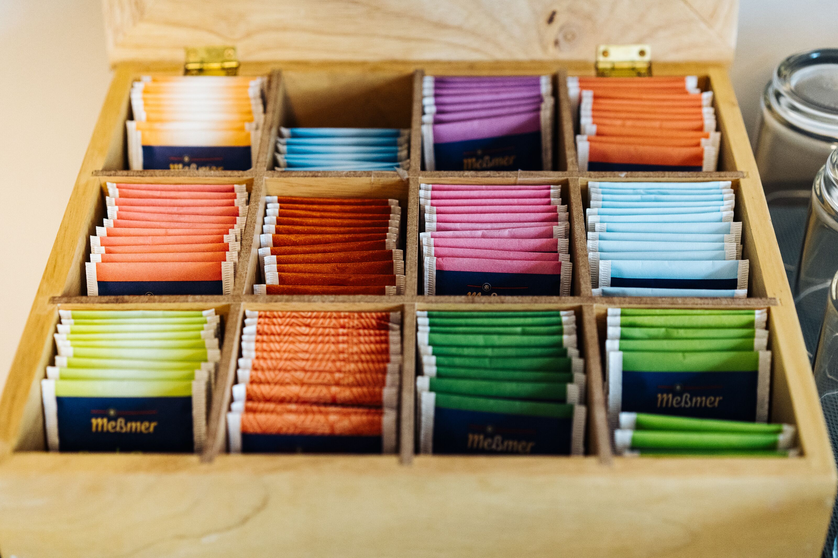A wooden box with compartments containing various colored cigarette packs.