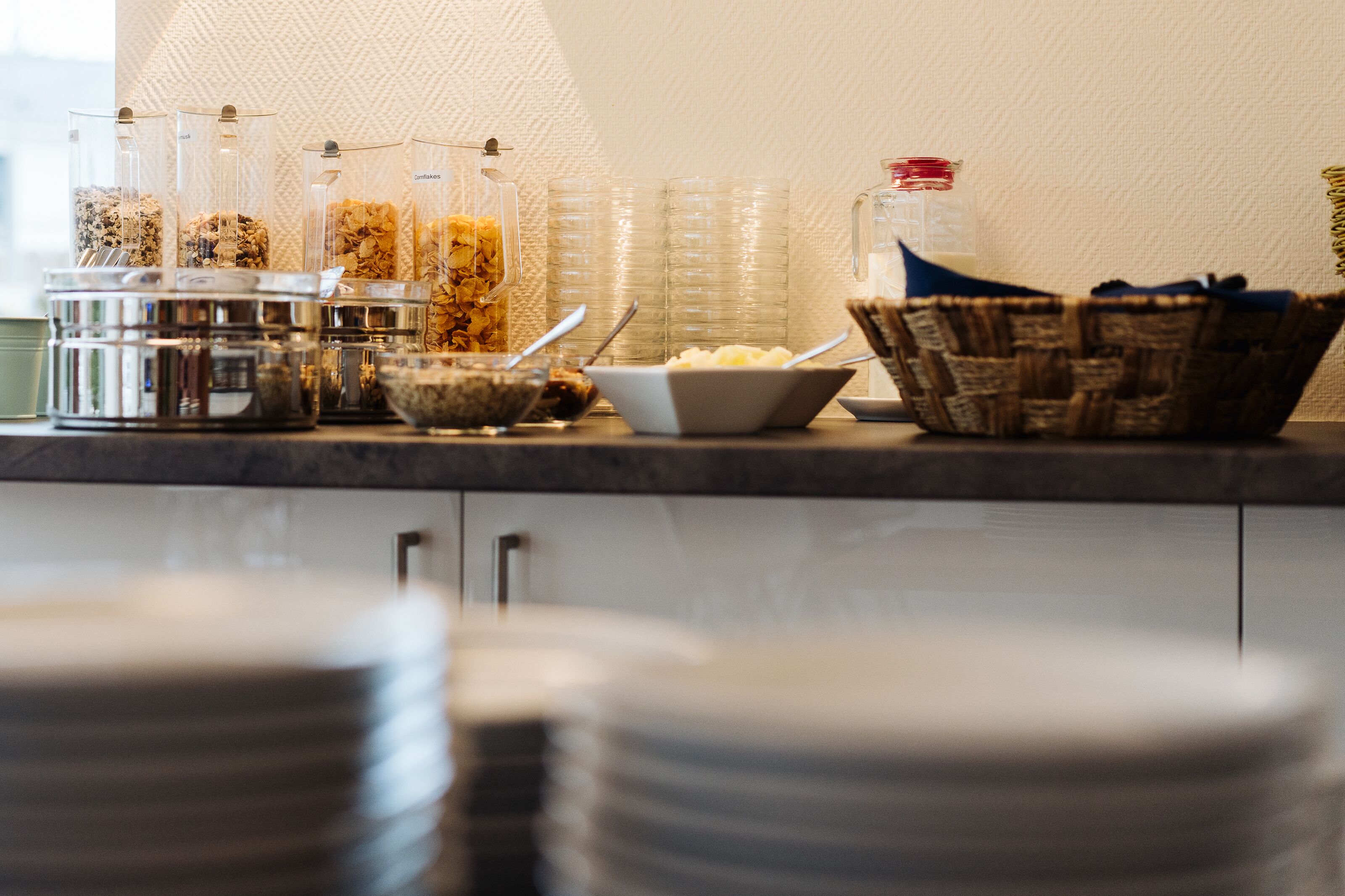 A buffet setup with various food containers and bowls on a counter.