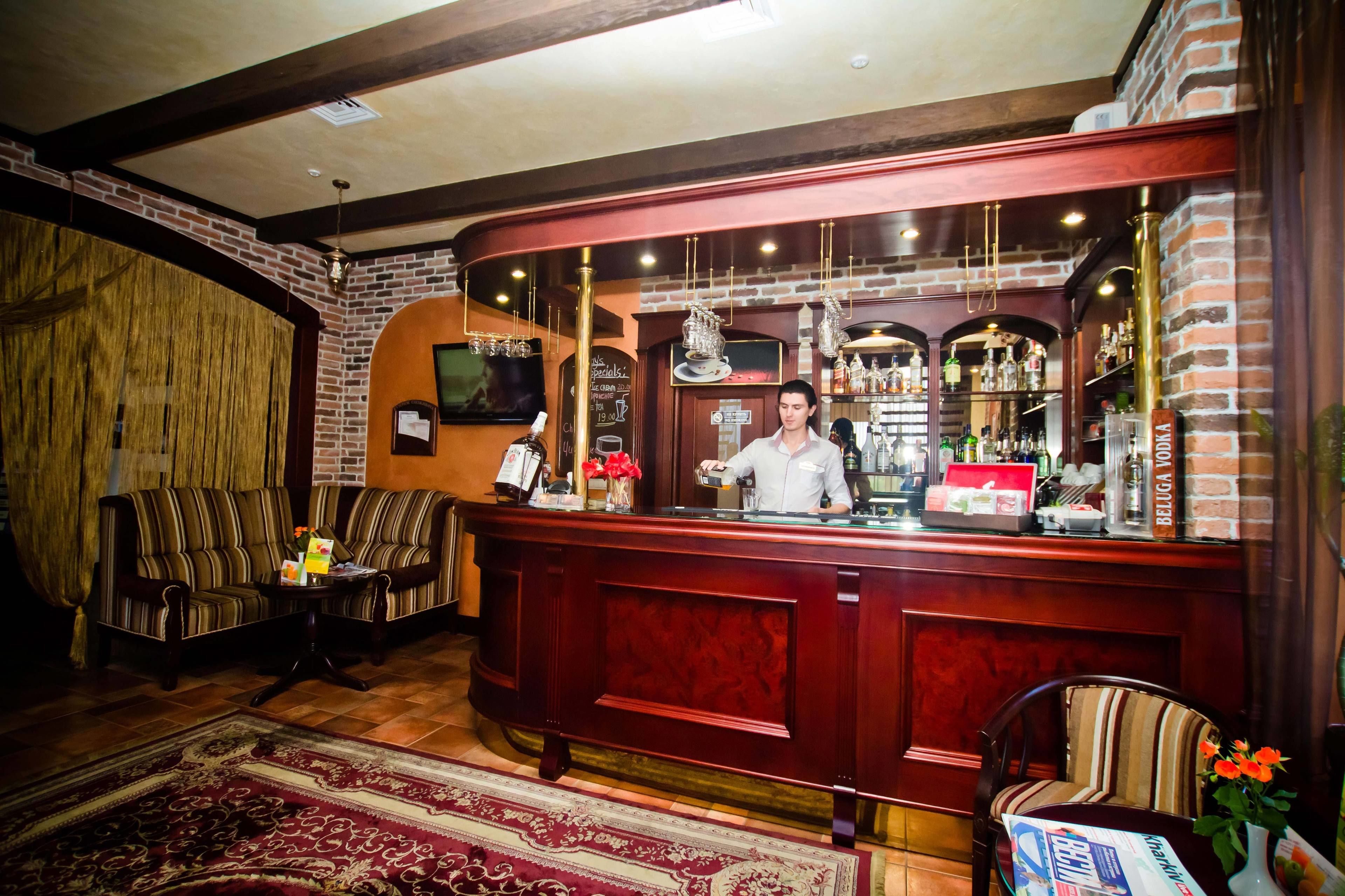 Zona de bar con un cantinero, muebles de madera y pared de ladrillo.