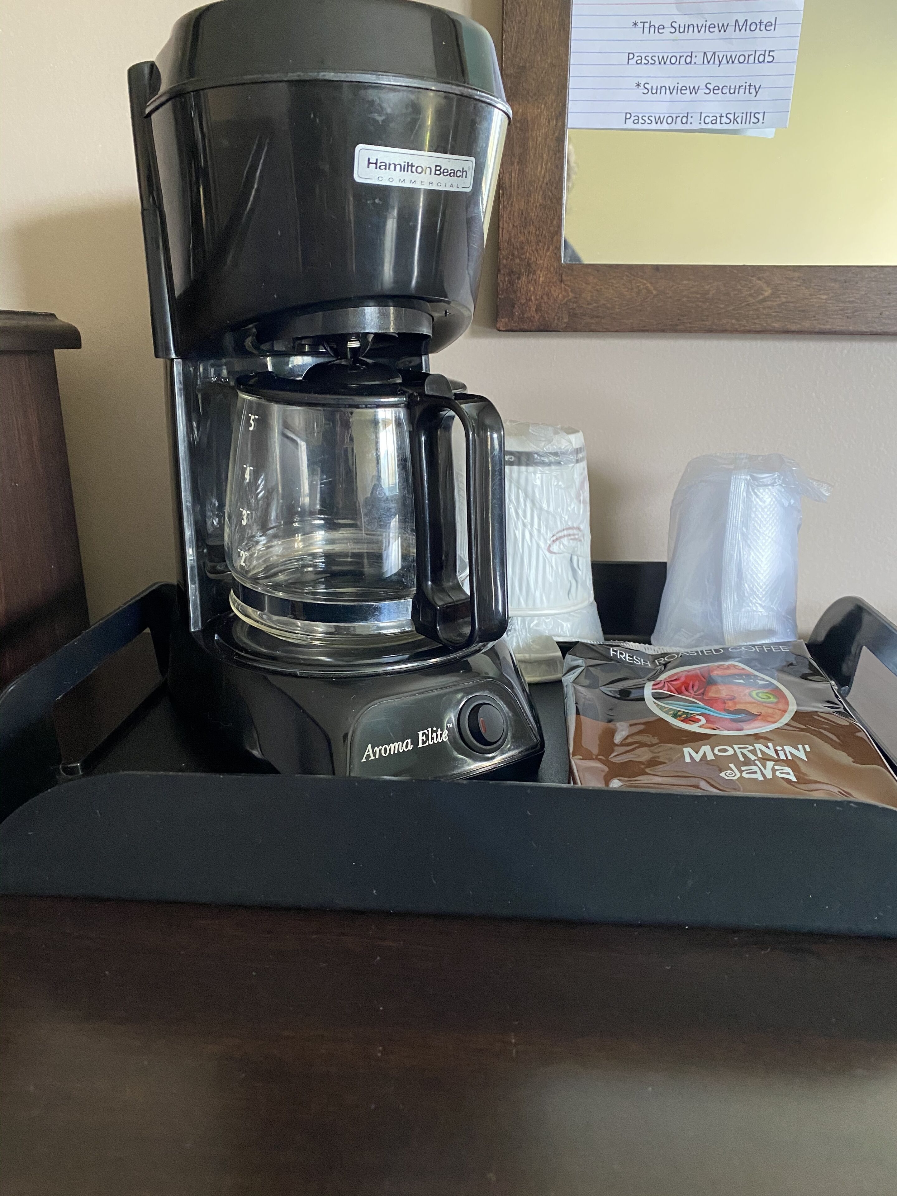 En Hamilton Beach-kaffebryggare står på ett bricka tillsammans med en påse Mornin' Java-kaffe och ett engångskaffefilter.