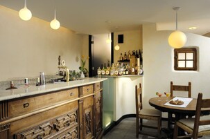 Una cucina con angolo bar, mobili in legno e lampade a sospensione.