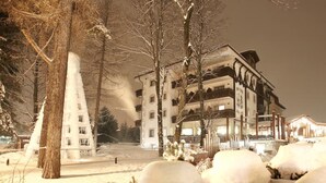 A snow-covered outdoor area with a building in the background. - Miramonti Park Hotel (Bormio)