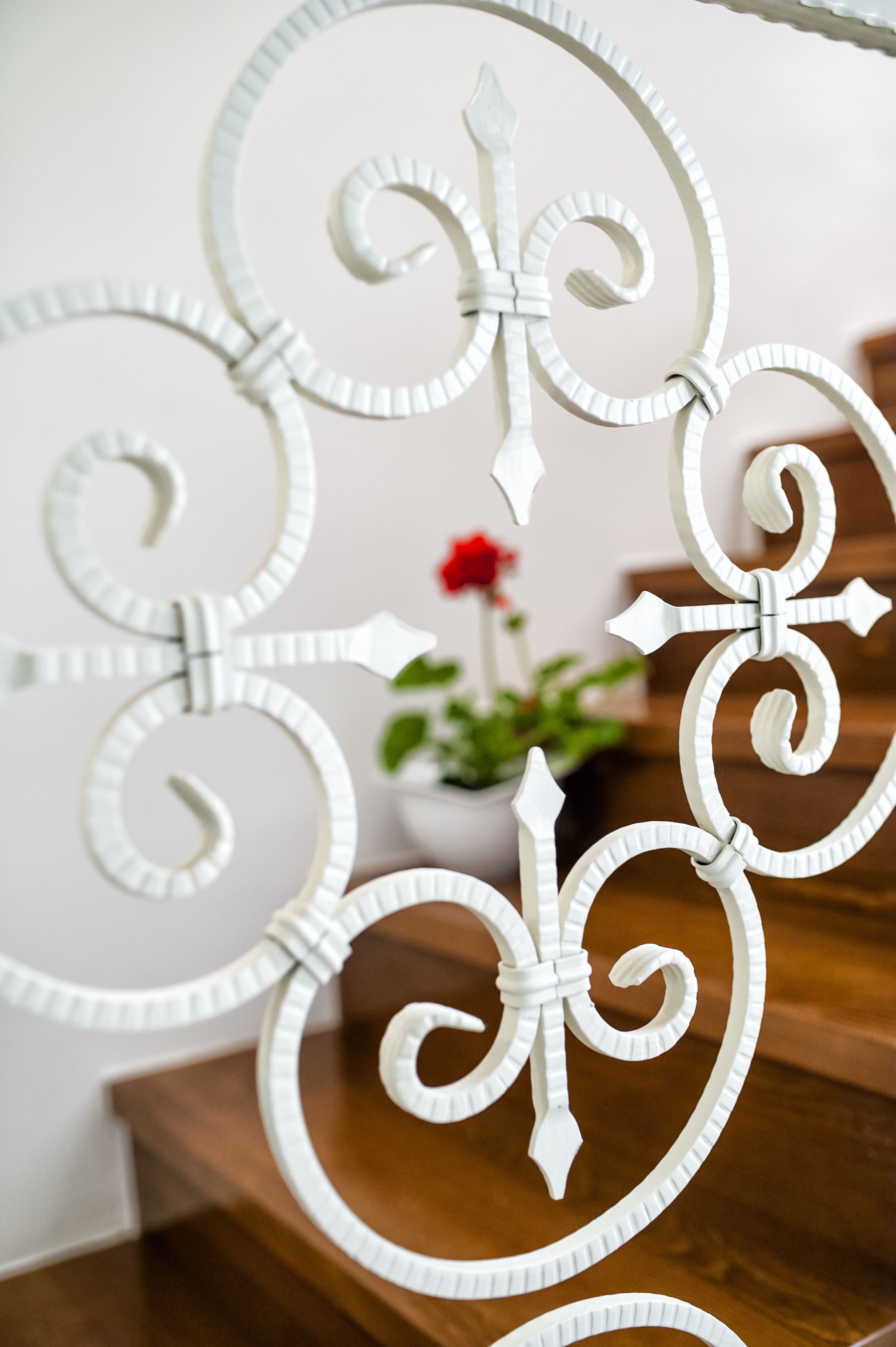 A close-up of a white metal staircase railing with intricate designs.