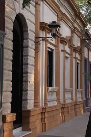 A building with classical architecture, featuring columns and a balcony.