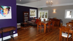 A dining area with wooden furniture, a chandelier, and a bookshelf. - Lupton Lodge (Glenbervie)