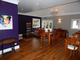 Un comedor con muebles de madera, una araña y una estantería.