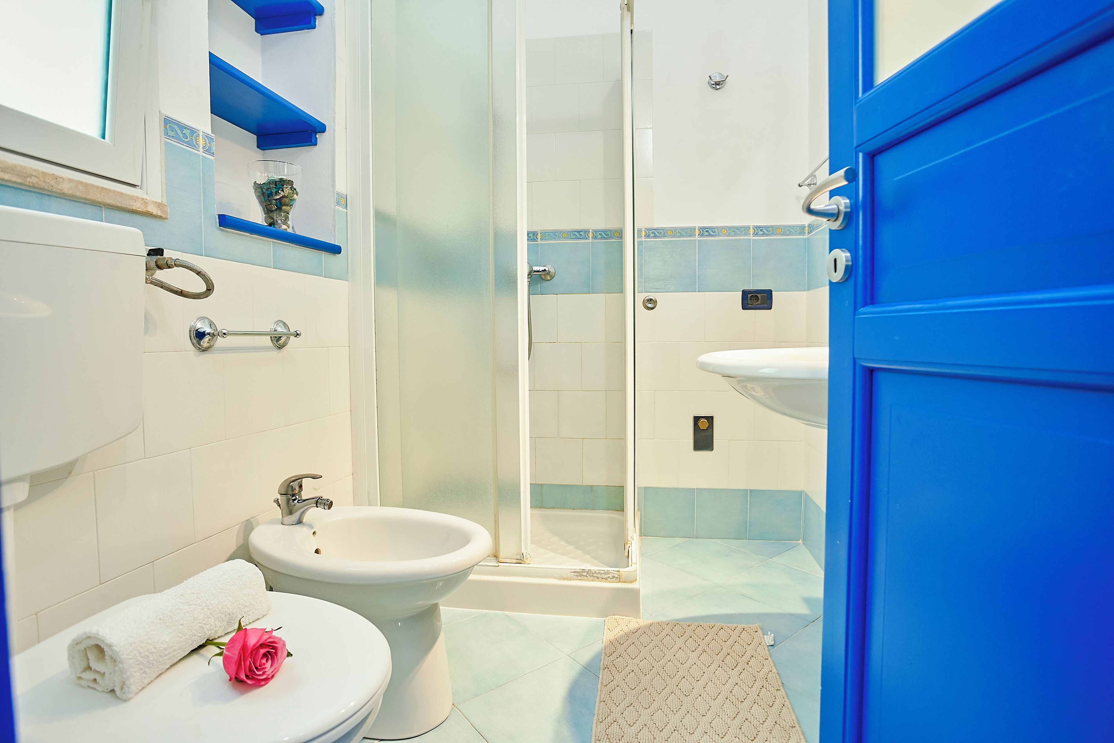 A bathroom with a toilet, bidet, and a glass-enclosed shower.