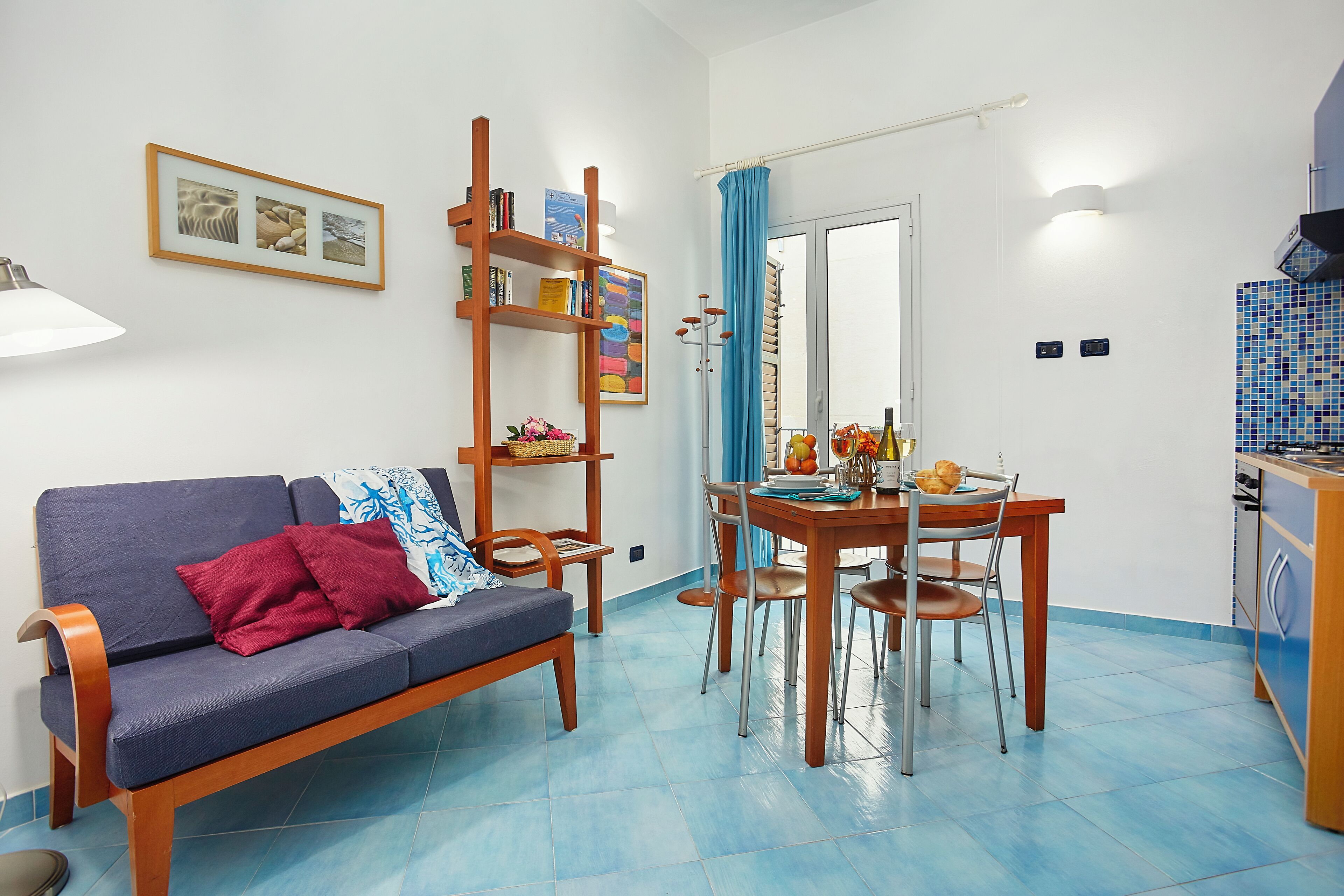 Una sala de estar con sofá, mesa de comedor y zona de cocina.