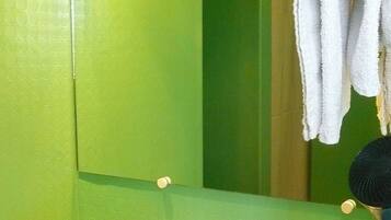 A bathroom with a green wall, a white sink, and a mirror.