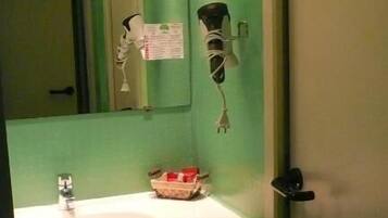 A bathroom with a green wall, a sink, and a mirror.