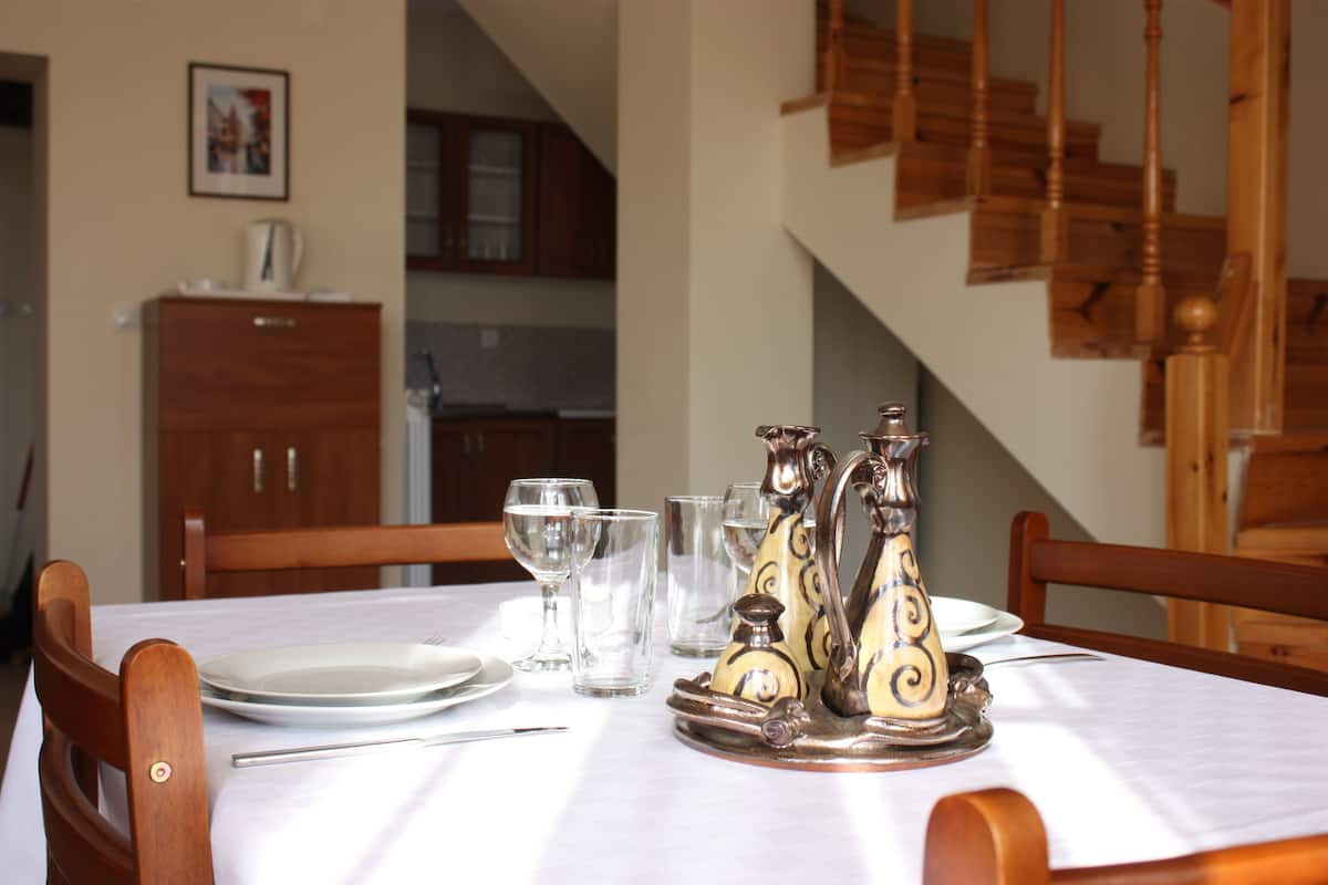 A dining table set with plates, glasses, and a decorative salt and pepper shaker.