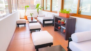 A balcony with a sofa, ottoman, and potted plants. - El Tumi (Huaraz)