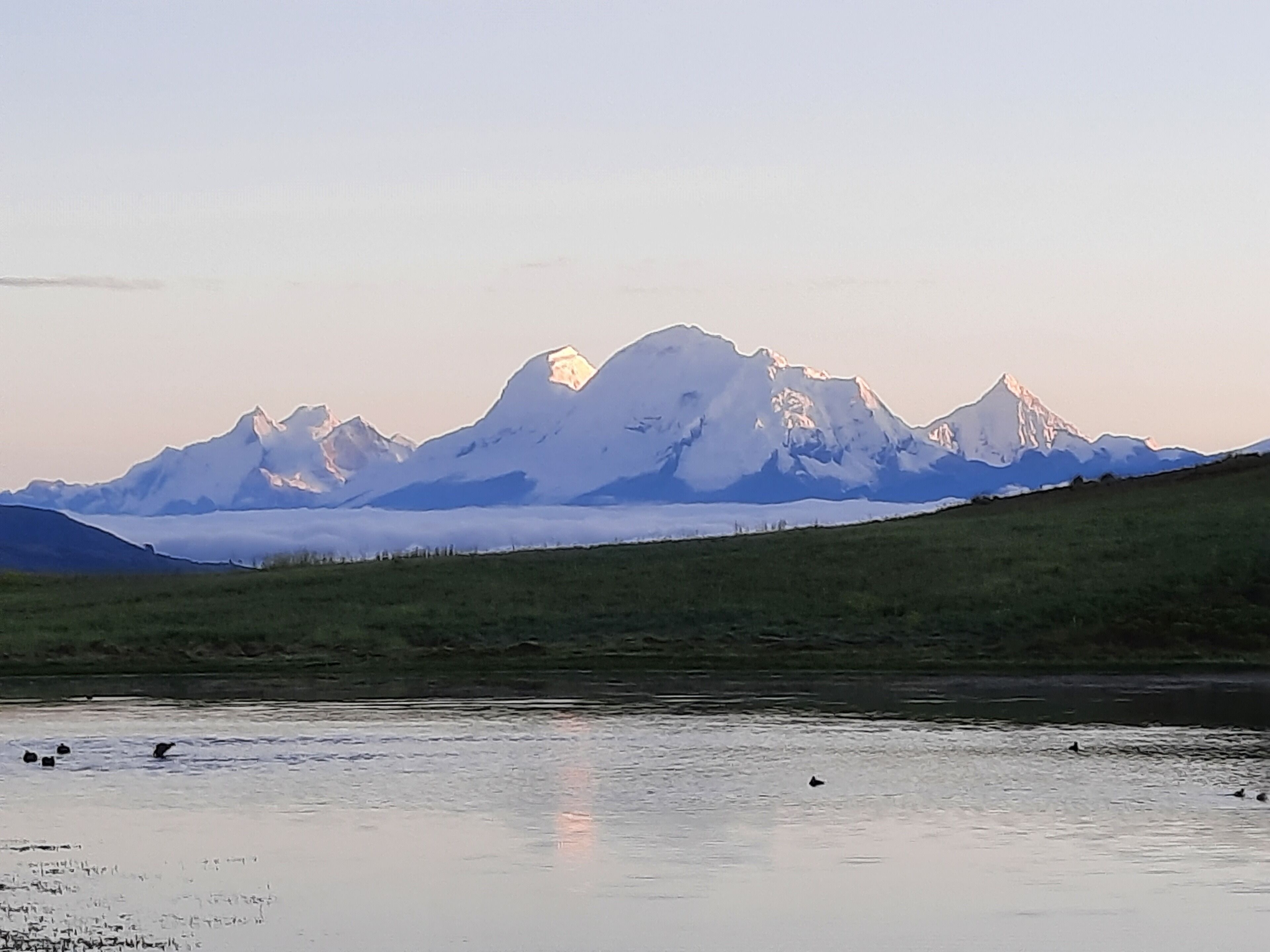 A mountain range with a lake in the foreground.