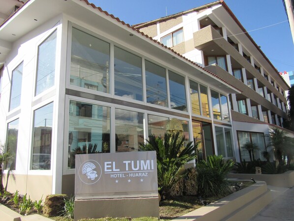 A modern hotel building with a sign reading "EL TUMI HOTEL - HUARAZ". - El Tumi (Huaraz)