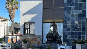 A modern building with a swimming pool, outdoor seating, and a 'Welcome' sign. - Le Blue Guesthouse (Gqeberha (Port Elizabeth))
