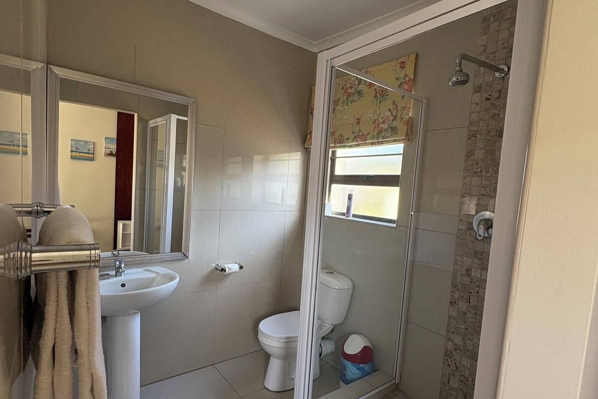A bathroom with a toilet, sink, and shower area.