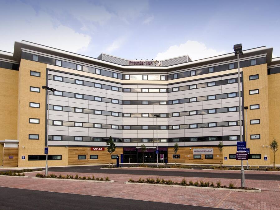 A modern building with a curved facade, multiple windows, and a sign for Costa.